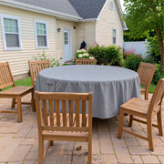 Gray round patio table cover by Khomo Gear on a backyard patio next to a house