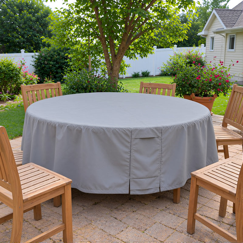 Khomo Gear round outdoor table cover on a patio with a garden and fence behind