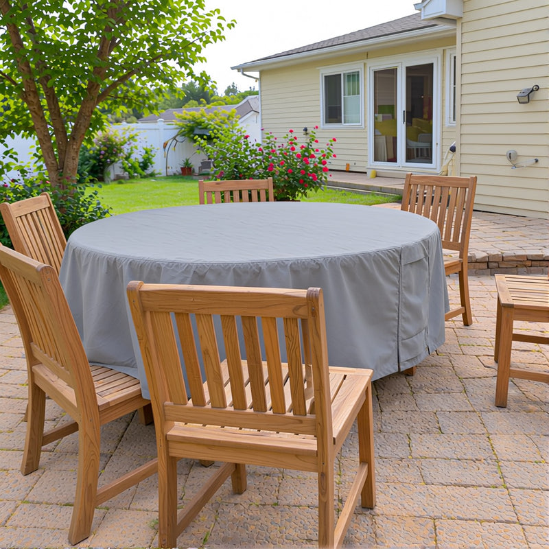 Khomo Gear gray round patio table cover with teak chairs on a backyard patio