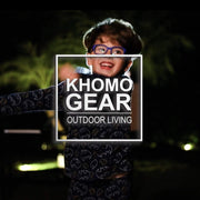 Child enjoying an outdoor movie night with the Khomo Gear logo