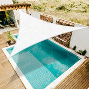 White Khomo Gear triangle shade sail over a backyard pool and wooden deck