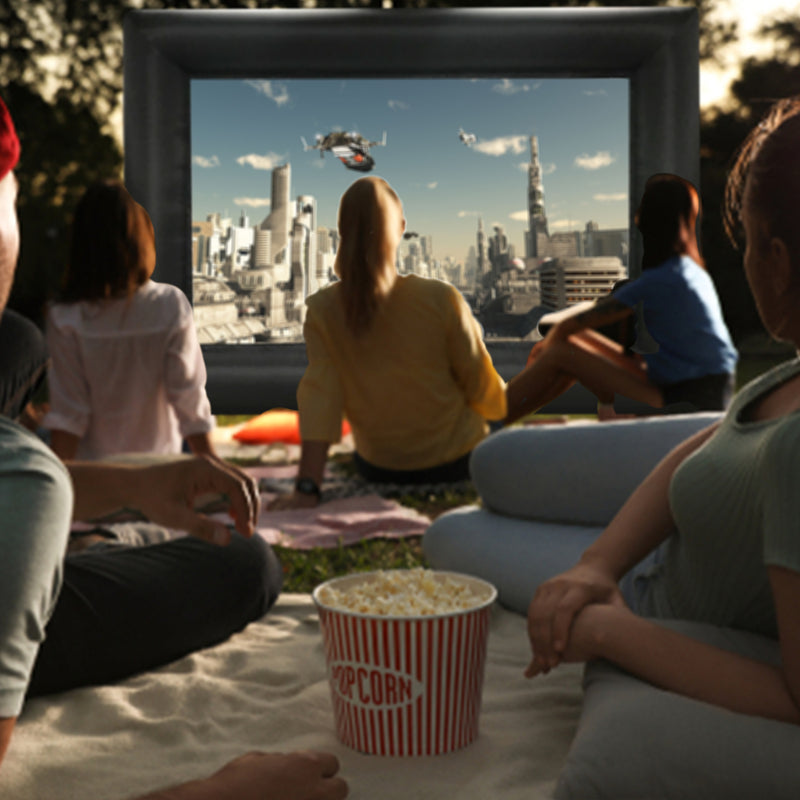 Family watching a movie on the Khomo Gear inflatable screen at an outdoor movie night